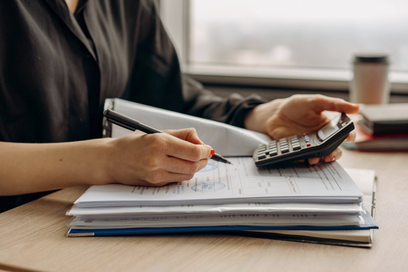 Pila de documentos de la empresa revisados con calculadora